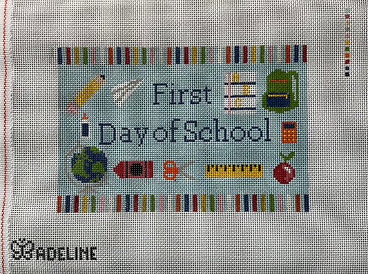 A needlepoint canvas on 13 mesh canvas, featuring the text 'First Day of School' surrounded by school-themed icons like a pencil, globe, books, and ruler.